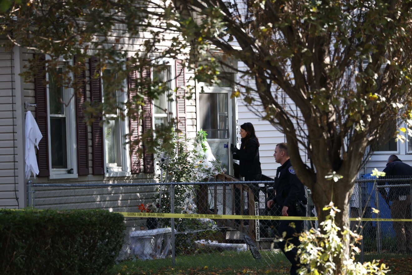 A Rochester Police Department Major Crimes investigator enters 278 Pennsylvania Ave., where a large party had been held Friday night into Saturday morning. Early Saturday, a mass shooting left a man and a woman dead and 14 others wounded.